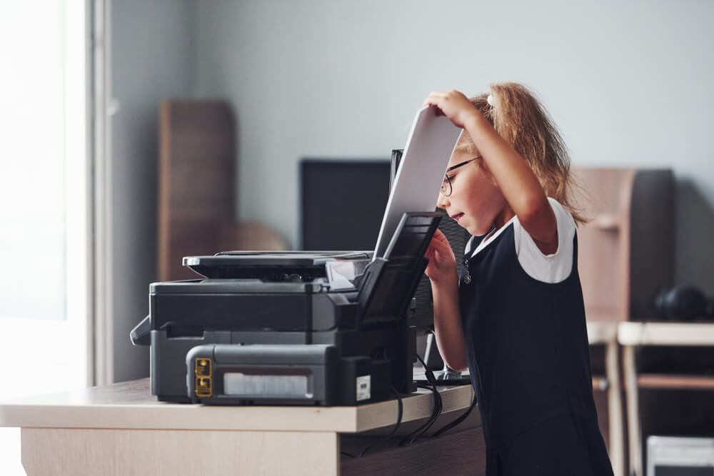 Girl Holds Paper and Puts It Into the Printer