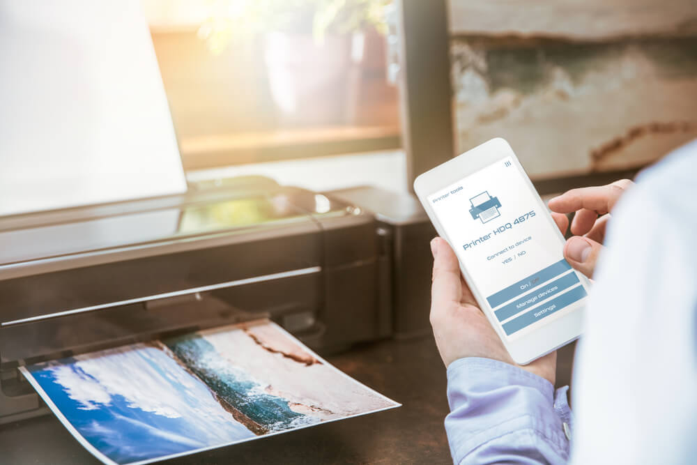 Man Configures the Connection of a Mobile Phone With a Wireless Printer